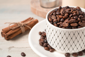Coffee beans in a mug, blurred in the foreground on a light background. Concept of coffee backgrounds.