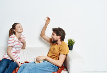 man and woman on the couch indoors chatting friends popcorn