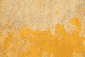 The background of the wall is yellow color. The surface is painted, the cement coating is weathered