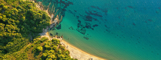 Aerial drone ultra wide panoramic photo of turquoise crystal clear beach in Skiathos island covered in pine trees, Sporades, Greece
