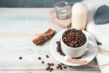 Coffee beans in a ceramic white Cup on a wooden background. Coffee background with space to copy. Cafe concept.