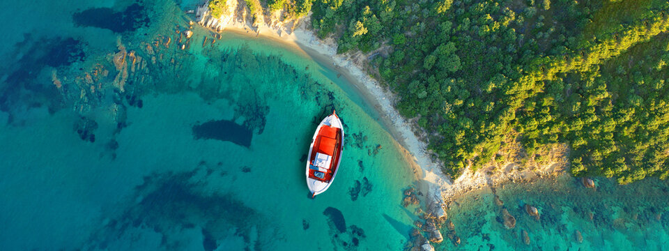 Aerial drone ultra wide panoramic photo of turquoise crystal clear beach in Skiathos island covered in pine trees, Sporades, Greece