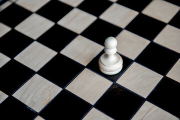 Chess piece pawn on chess game board,white figure on black square