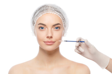 Portrait of young woman wearing medical cap, getting ready for filler injection to eliminate aging effect, isolated on white background