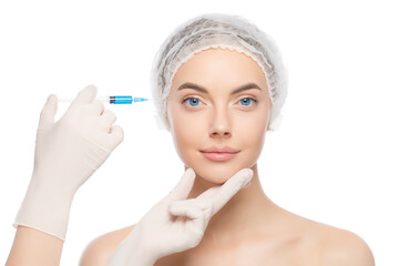 Close-up portrait of young woman wearing medical cap, getting ready for filler injection to eliminate aging effect, isolated on white background