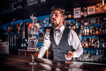 Focused bartending makes a cocktail in the nightclub
