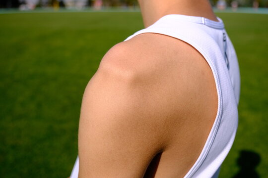 sportsman with shoulder dislocation in turf/sports field. shoulder bone is clarified. 