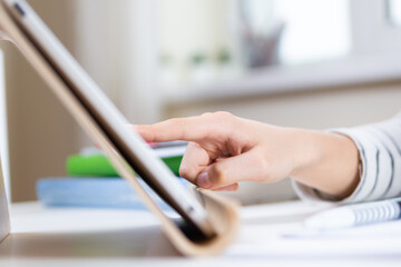 Online learning, remote education background. Kid hand using digital tablet computer