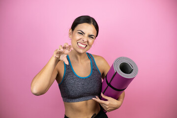 Young beautiful woman wearing sportswear over isolated pink background smiling funny doing claw...