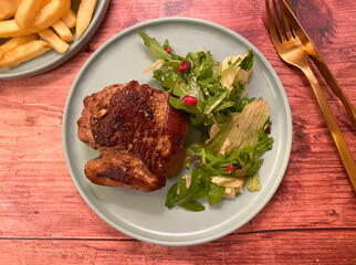 Beef steak fillet with french fries and green salad.