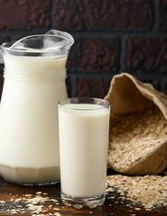 Vegan Oat milk in glass on rustic wooden table