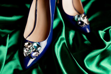 blue womens stiletto heels on a green background