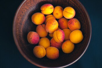 Many apricots in a deep clay plate