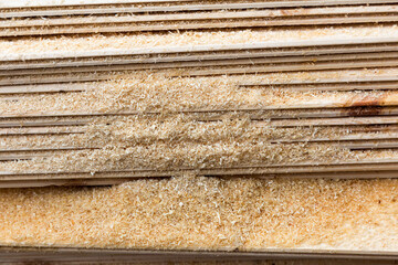 Planed boards, lining, lie horizontally, covered with sawdust.
