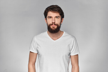 cheerful emotional bearded man gesturing with his hands close-up light background