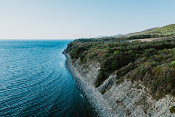 Aerial panoramic view of blue sea coast and rock cliffs. Black sea, wild nature.