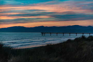 Sunset at the coast with a pier in New Zealand