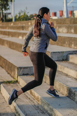 Latin Hispanic woman with black hair doing yoga exercise outdoors in a park