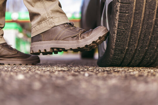 a man's boot kicks on a flat tire. puncture of the wheel. deflated tire. selective focus.
