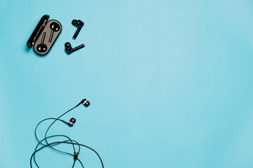 Wired and wireless bluetooth headphones on a blue background