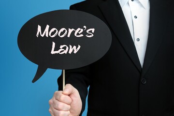 Moore's Law. Businessman holds speech bubble in his hand. Handwritten Word/Text on sign.