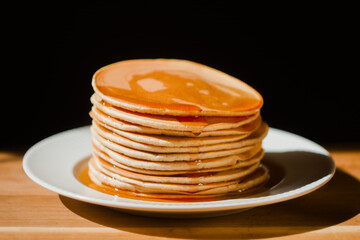 Close up tasty stack pancakes with maple syrup. Sweet dessert for breakfast. 