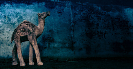 Silhouette of a camel on a wall and woode background. Background of annual rings. Camel for travelers.