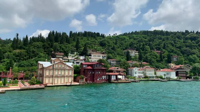 Footage of luxury houses in upscale neighborhood called "Kandilli" by Bosphorus in Istanbul. It is a beautiful summer scene on cloudy summer day. Camera moves forward.