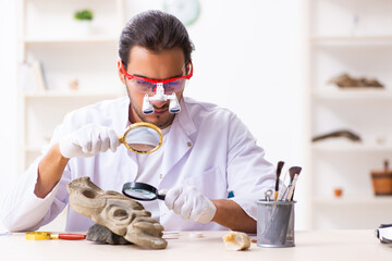 Young male archaeologist studying ancient african stonemask