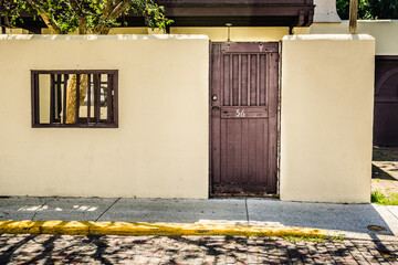Wooden Door in a Concrete Wall Along a Cobblestone Street