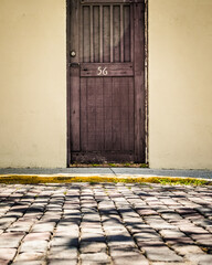 Wooden Door Numbered 56 Along a Cobblestone Street