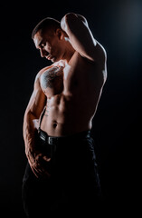 Fototapeta na wymiar Portrait of strong handsome man on black- studio shot