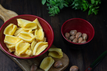 Buah Nangka or Jackfruit, one of tropical fruits popular in Indonesia. Cut into  half on red bowl and the seeds at behind. Dark wooden background. 