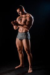 Fototapeta premium Personal fitness trainer. Strong man flexing his muscles