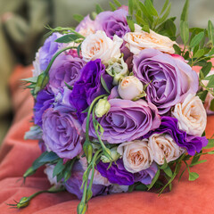 wedding bouquet on an orange pillow, bouquet of bride from rose cream spray, rose bush, rose purple Memory Lane, violet eustoma, eucalyptus