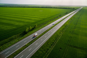 ambulance car driving on asphalt road along the green fields. seen from the air. Aerial view...