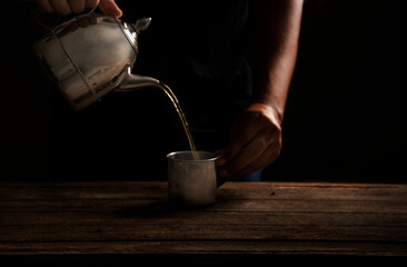 Pour the hot water of the french press tea into a glass.