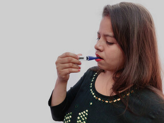 Indian woman with a thermometer in her mouth measures the temperature. Chills, fever and other symptoms of flu and illness on grey background