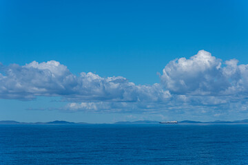 Ship with islands in background on Coral Sea