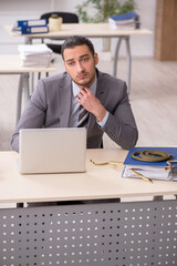 Young male employee with snake in the office