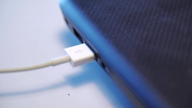 Close up of hand putting USB cable into external hard disk isolated on white background. Media. USB cable for transfering data from others device to computer, accessories for work, social network.