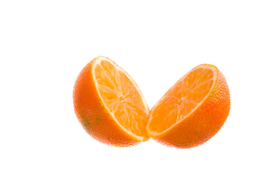 Mandarina partida por la mitad con un cuchillo con fondo blanco.