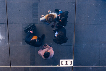 Bird eye perspective of a team of colleagues (friends) standing next to each other and talking.