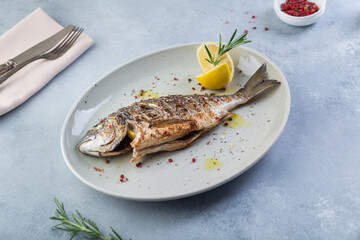 Delicious baked fish with lemon and spices from the chef. Original presentation.
