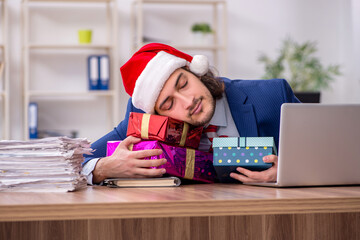 Young male employee working in the office at Christmas Eve