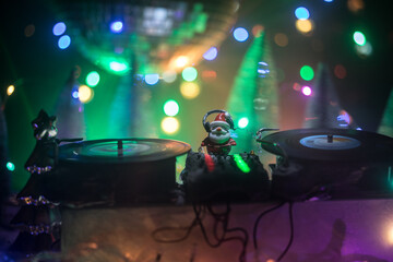 Obraz na płótnie Canvas Dj mixer with headphones on dark nightclub background with Christmas tree New Year Eve. Close up view of New Year elements on a Dj table. Holiday party concept. Empty space