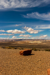 Lone rock on the edge of a flat land with distant hills and beautiful cloudscape, Wahweap lookout,...