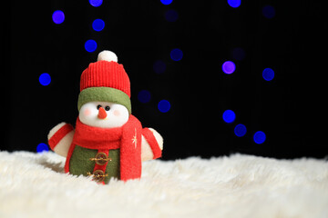 Muñeco de nieve con bufanda y suéter con luces de fondo azules