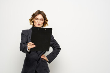 Obraz premium business woman in a suit with documents in hands light background curly hair hairstyle