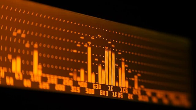 The professional concert equalizer has a yellow spectrum analyzer on the display that analyzes the frequency range of music or any sound and can change it. Closeup